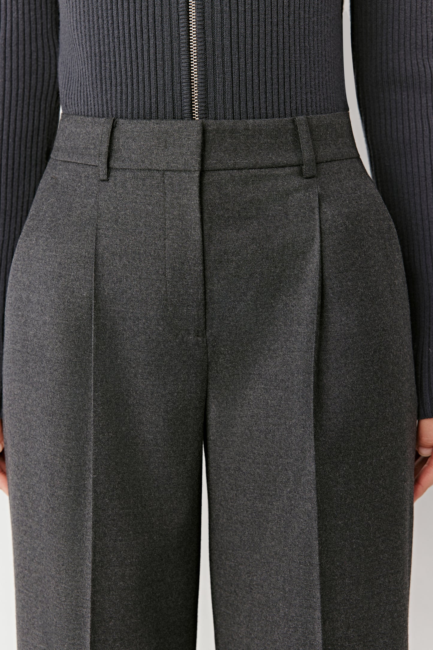 Close-up of the waistband and pleats, showing the flannel texture and refined tailoring.