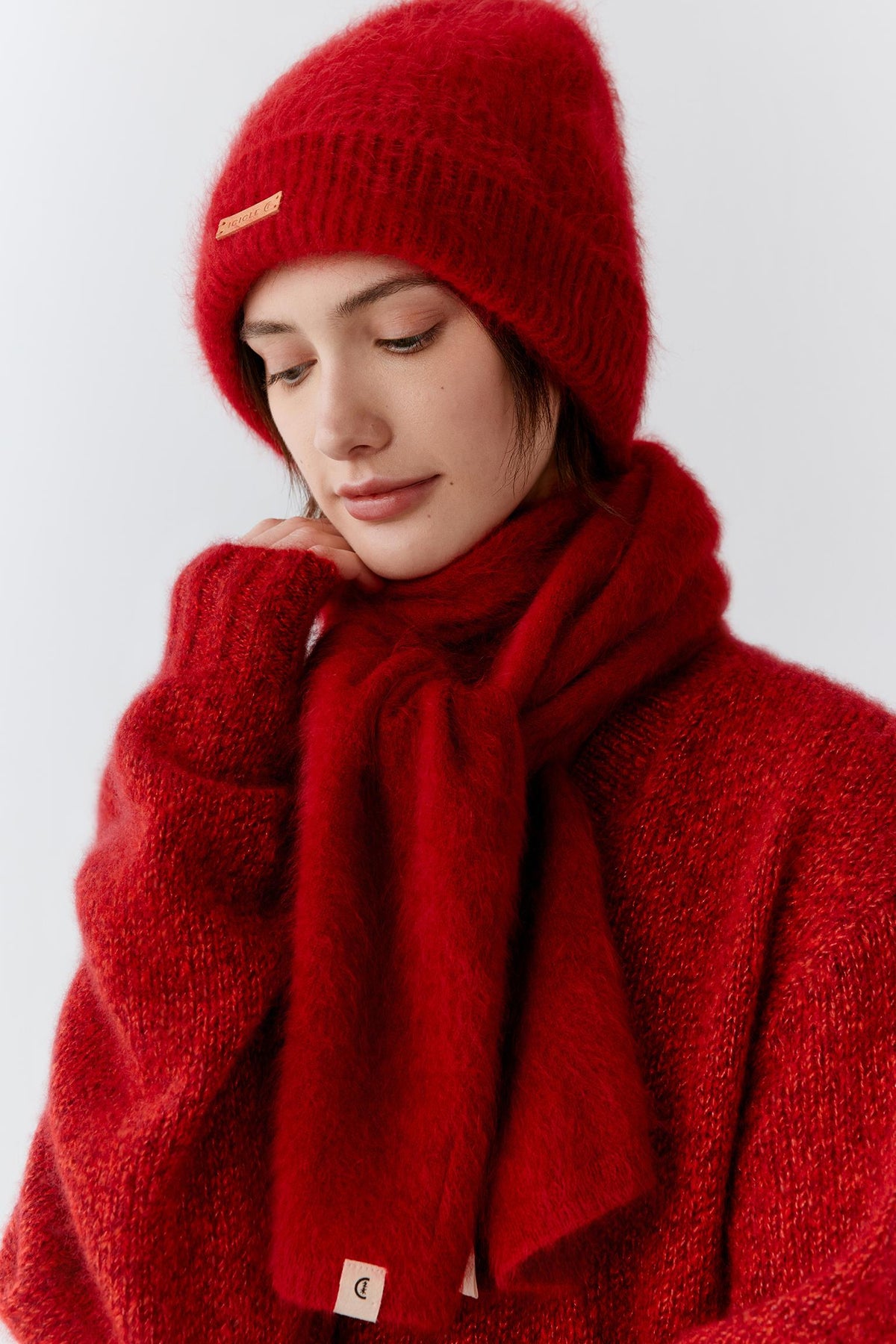 Three-quarter view showing the scarf wrapped generously around the neck with layered folds and natural volume. The lightweight cashmere drapes softly over the body, demonstrating its supple hand, fluid movement and comfortable warmth.