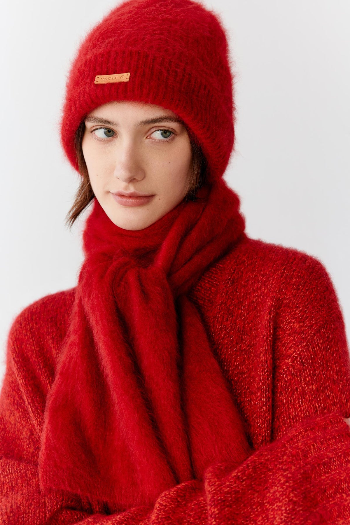 Front view showing the beanie worn as part of a coordinated winter ensemble. The softly structured knit conforms naturally to the head, creating a comfortable and enveloping fit while maintaining a clean, rounded silhouette. The lightweight cashmere texture adds visible softness and volume.