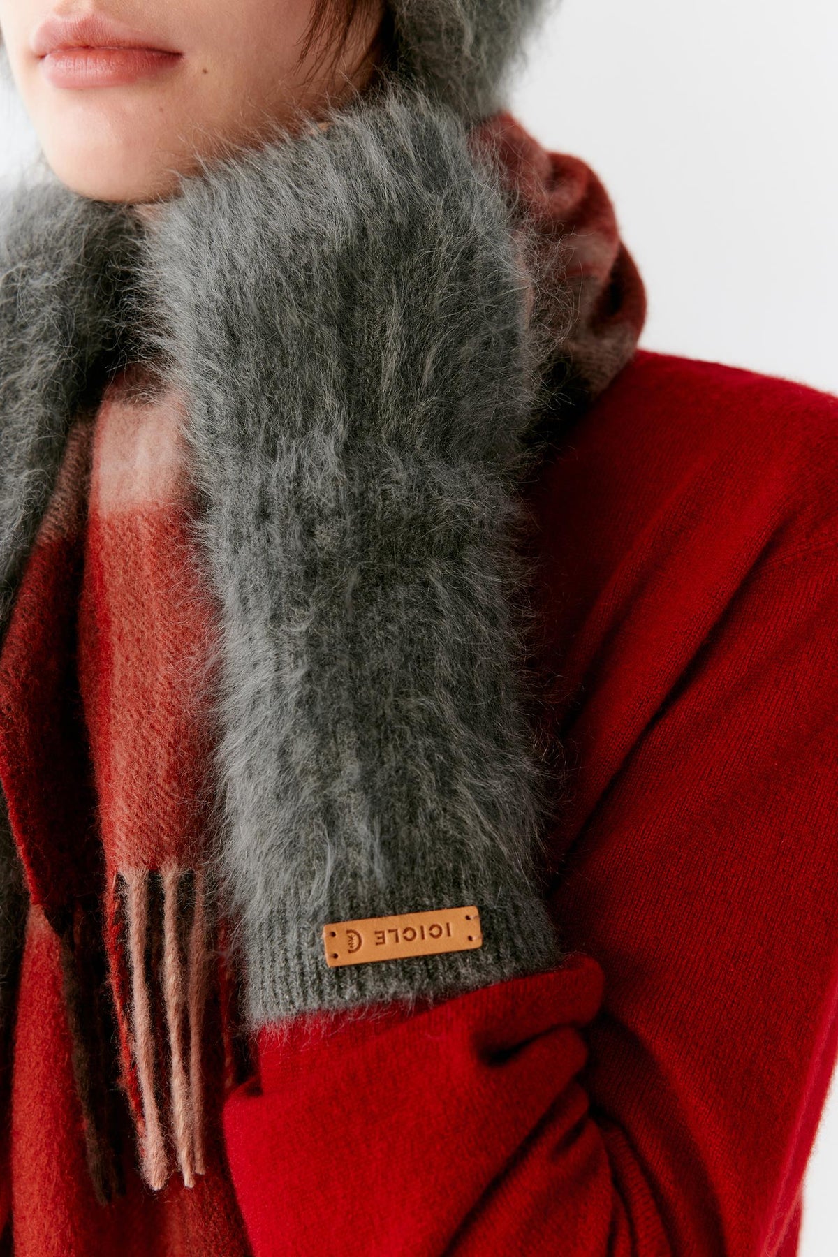 Close-up of a woman wearing grey brushed cashmere gloves, highlighting the ribbed cuffs and soft brushed texture.