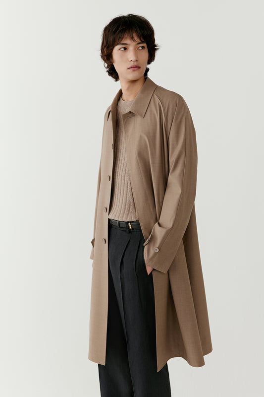 Three-quarter view showing the coat slightly open, revealing the clean interior structure and relaxed tailoring.