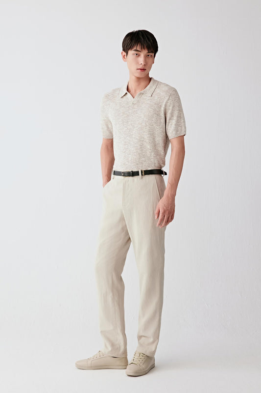 Full-length front view of a beige cotton and silk knit pullover with a soft collar, styled with matching trousers.