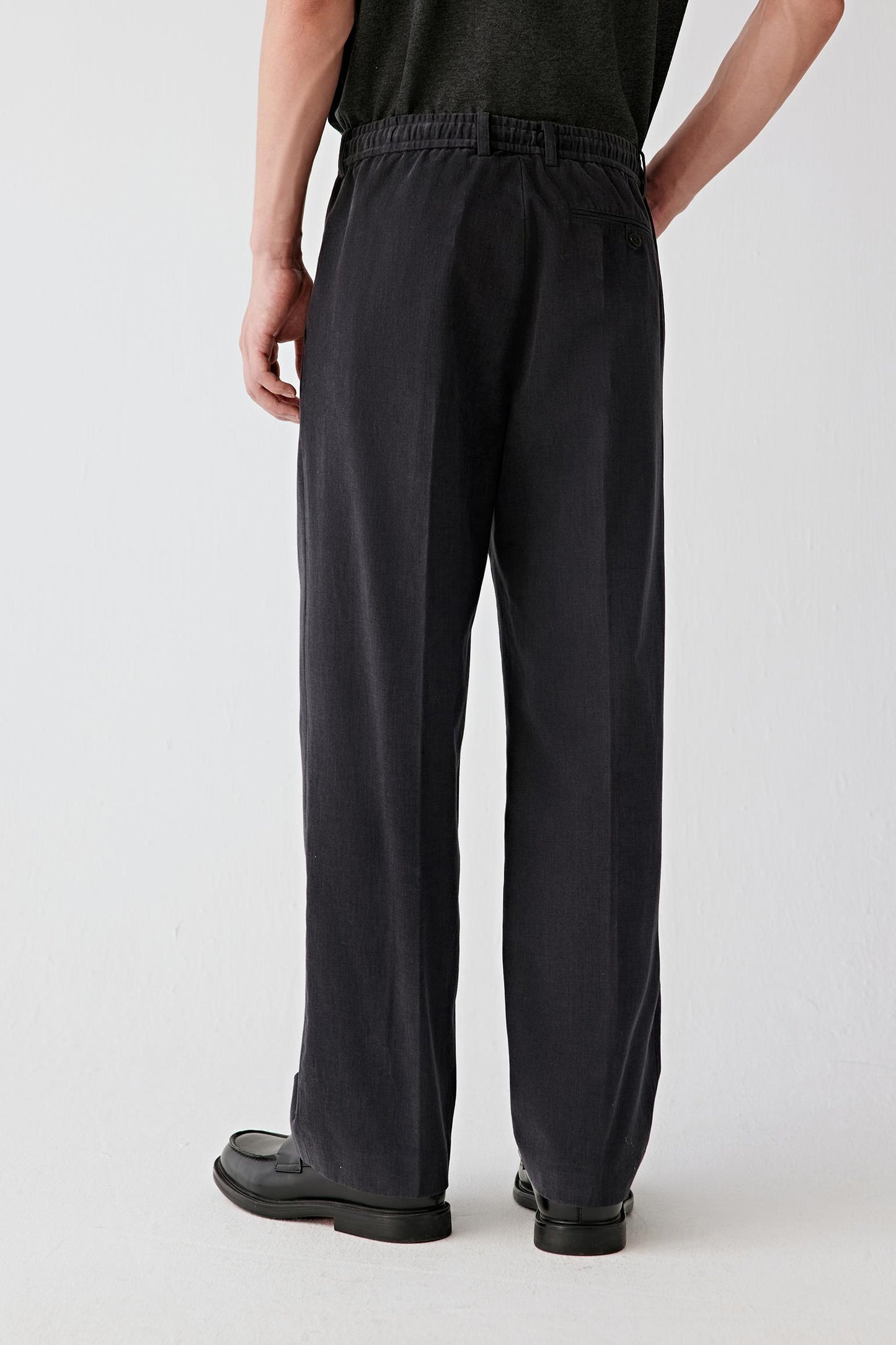 Back view emphasizing the fluid fall of the leg, relaxed silhouette and ease of movement.