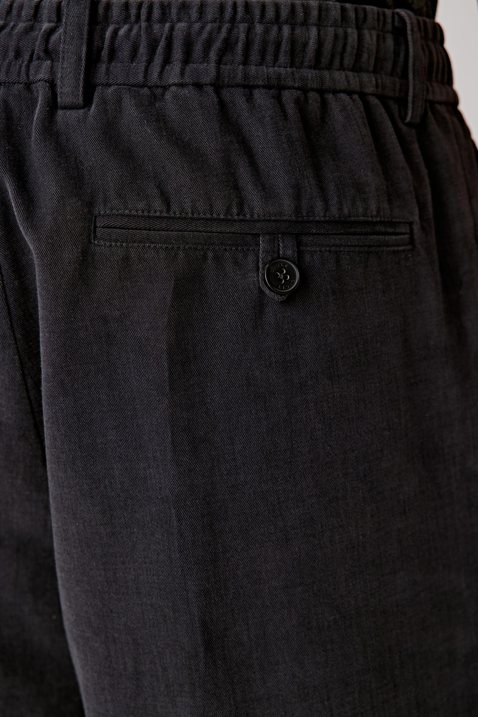 Close-up of the waistband detailing the drawstring waist and subtle central front pleat, with visible stitching and fabric grain.