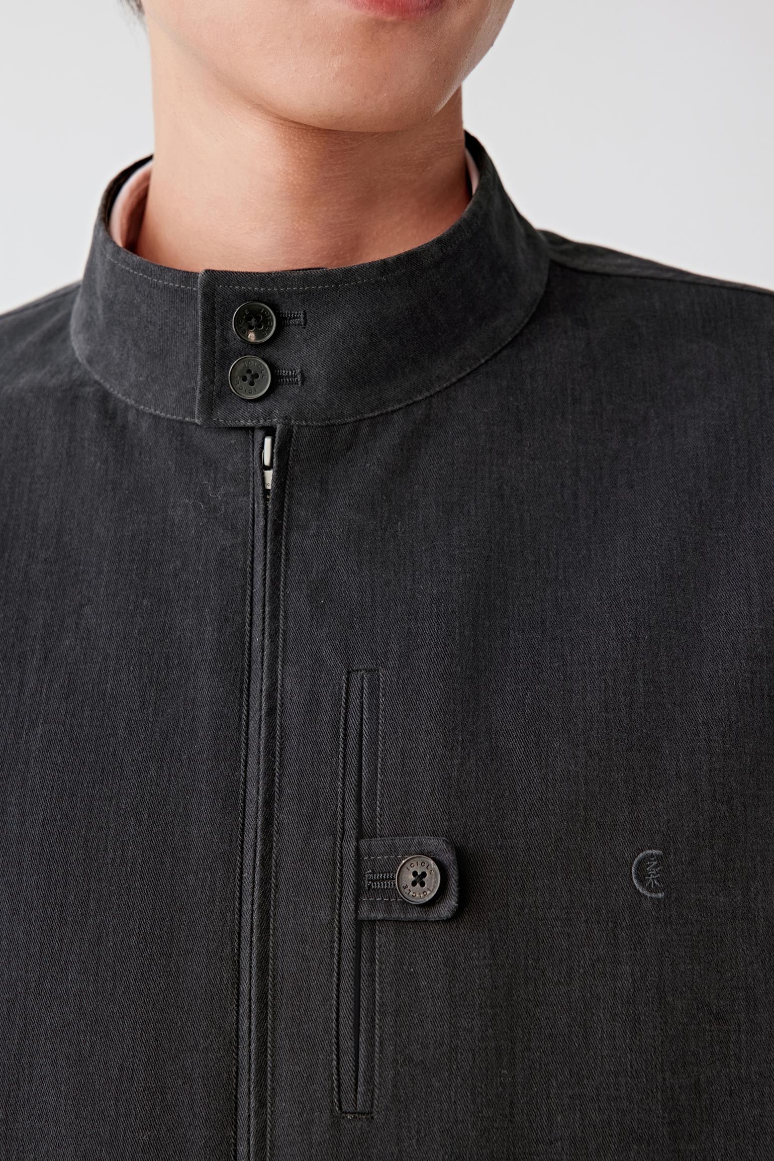 Close-up of the front pocket and button detailing on the twill fabric.