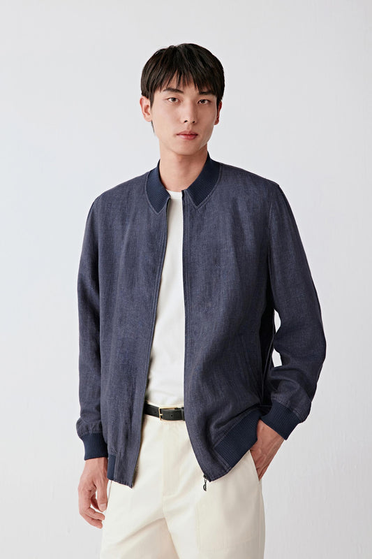 Mid-length front view focusing on the upper body, emphasizing the ribbed collar, zip closure and structured neckline, with the deep blue-black tone revealing slight tonal variation across the linen surface
