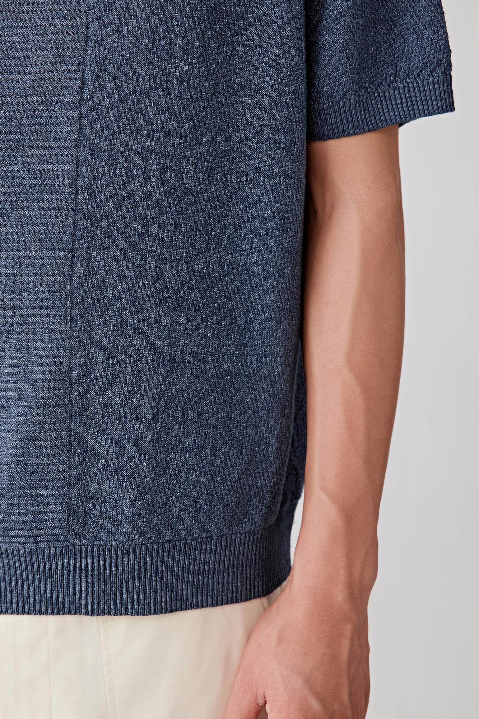 Close-up of the sleeve and side body, highlighting the short sleeve cut, ribbed finishing and the dry hand feel of the linen yarn, with visible texture and natural irregularities enhancing the fabric character