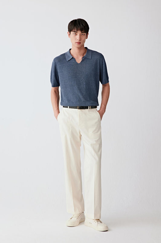 Full-length front view showing the overall silhouette paired with light trousers, emphasizing clean proportions, the straight fall of the garment and the lightweight, breathable structure of the knit