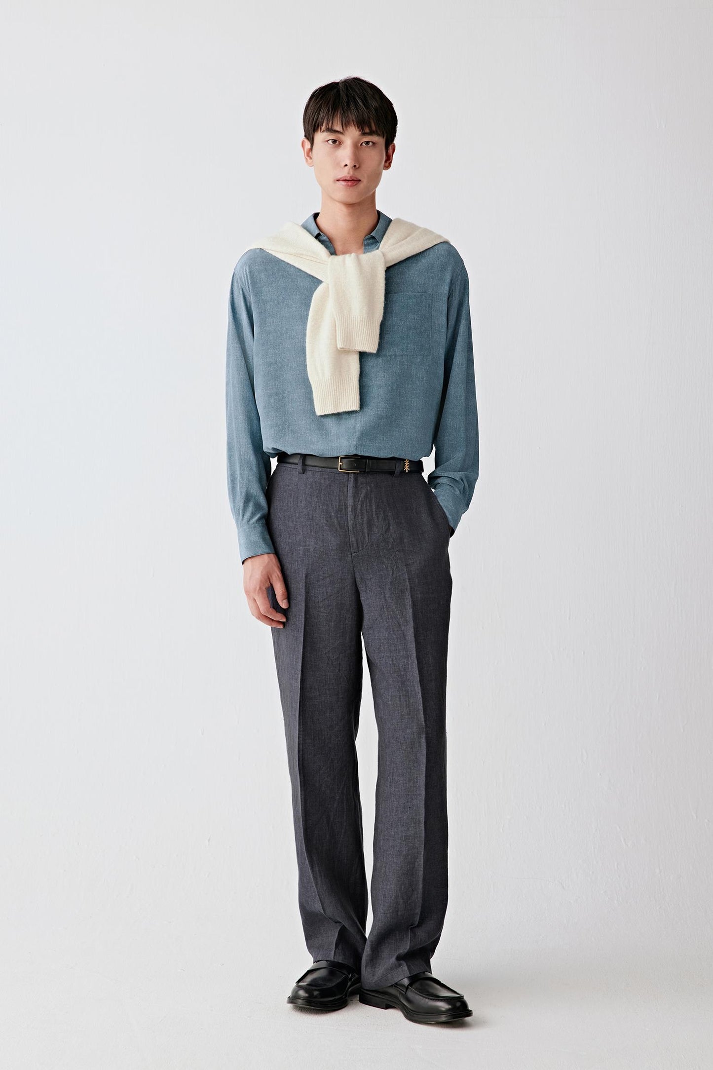 Full-length front view of a man standing facing forward wearing deep blue linen drawstring trousers paired with a light top, highlighting the straight-leg cut, relaxed silhouette and lightweight structure, with a dry hand feel and subtly textured surface characteristic of plain-woven linen