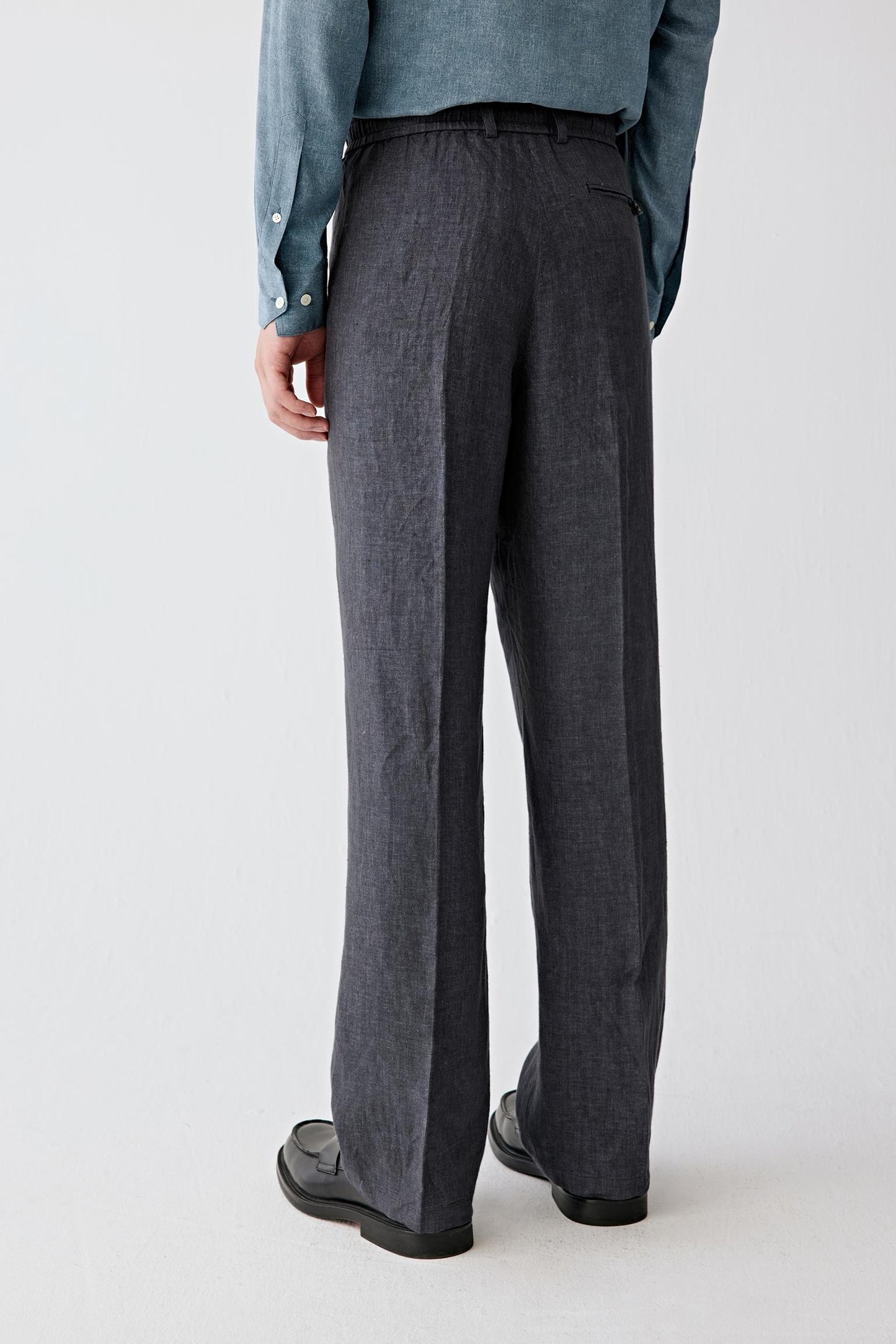 Full-length back view showing the rear silhouette, highlighting the straight cut and continuous vertical fall from waistband to hem, with a balanced structure that maintains shape while allowing natural movement