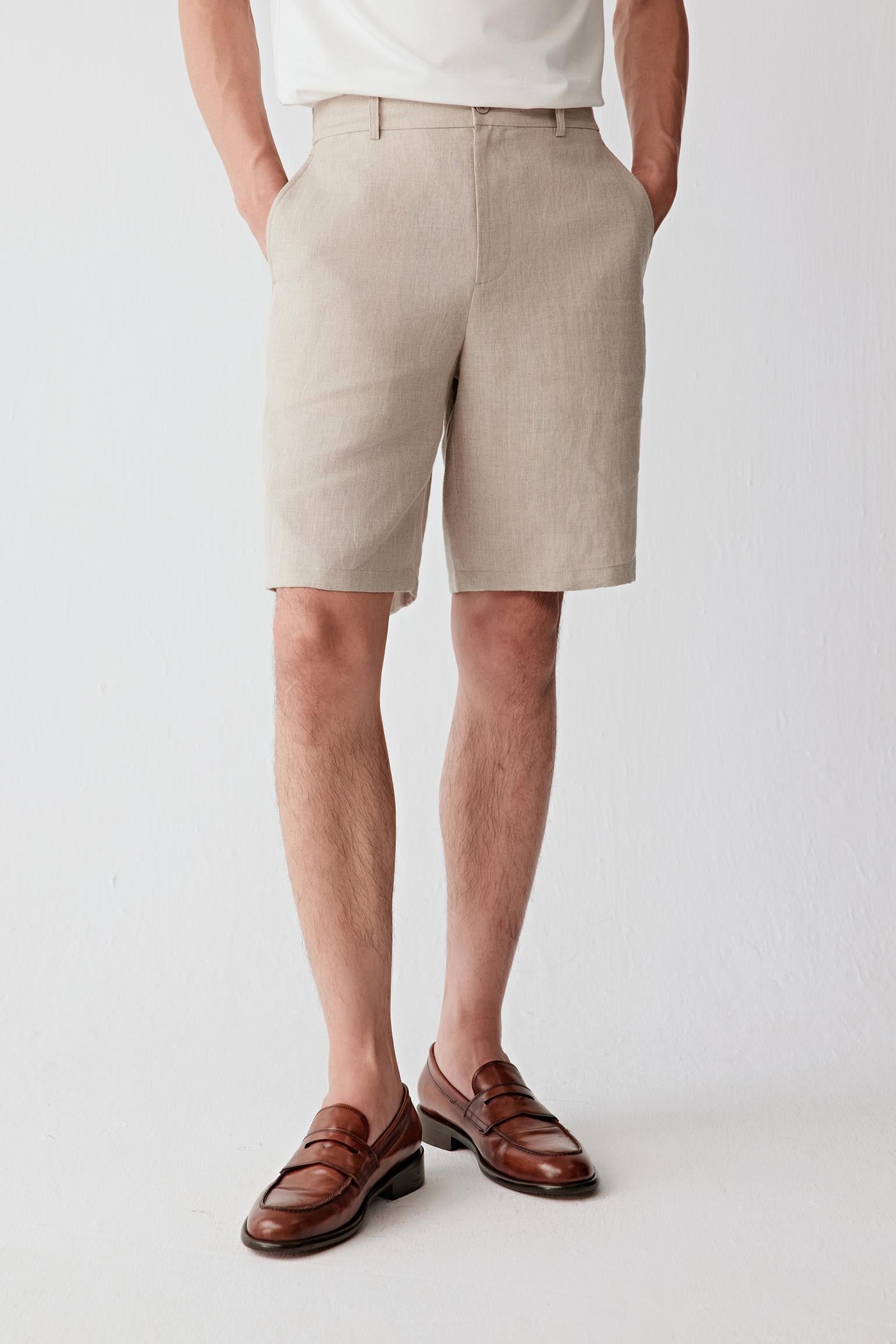 Three-quarter view showing the tailored construction, structured waistband and clean proportions of the shorts. The image emphasizes the dry hand of the linen fabric and the balanced silhouette created by the straight cut.
