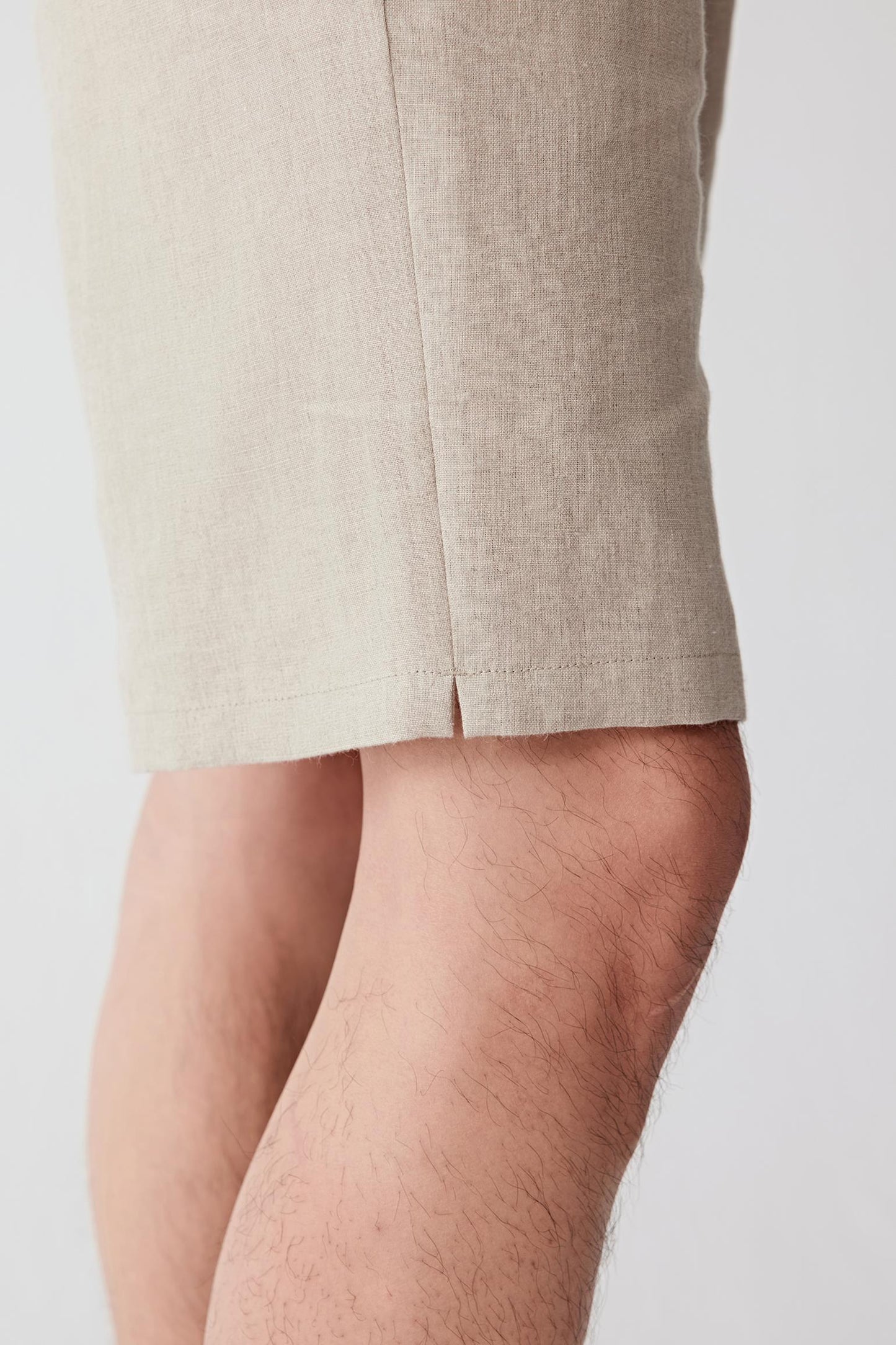 Close-up of the leg area showing the visible weave, lightly textured surface and characteristic irregular texture of linen. The image reveals the natural depth and dry hand of the fabric.