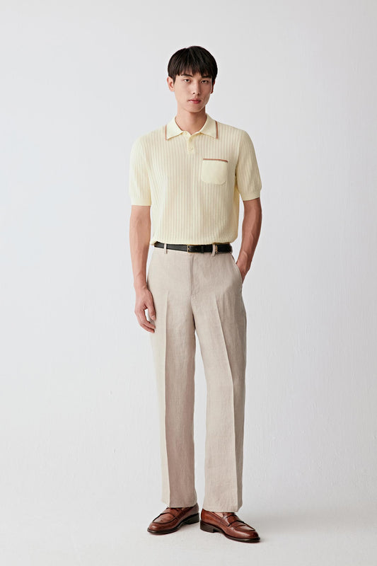 Front view of a man wearing taupe trousers in plain-woven linen, highlighting the straight-leg silhouette, lightweight structure and naturally textured surface. The linen fabric reveals subtle irregularities in the weave, creating understated tonal variation throughout the garment.