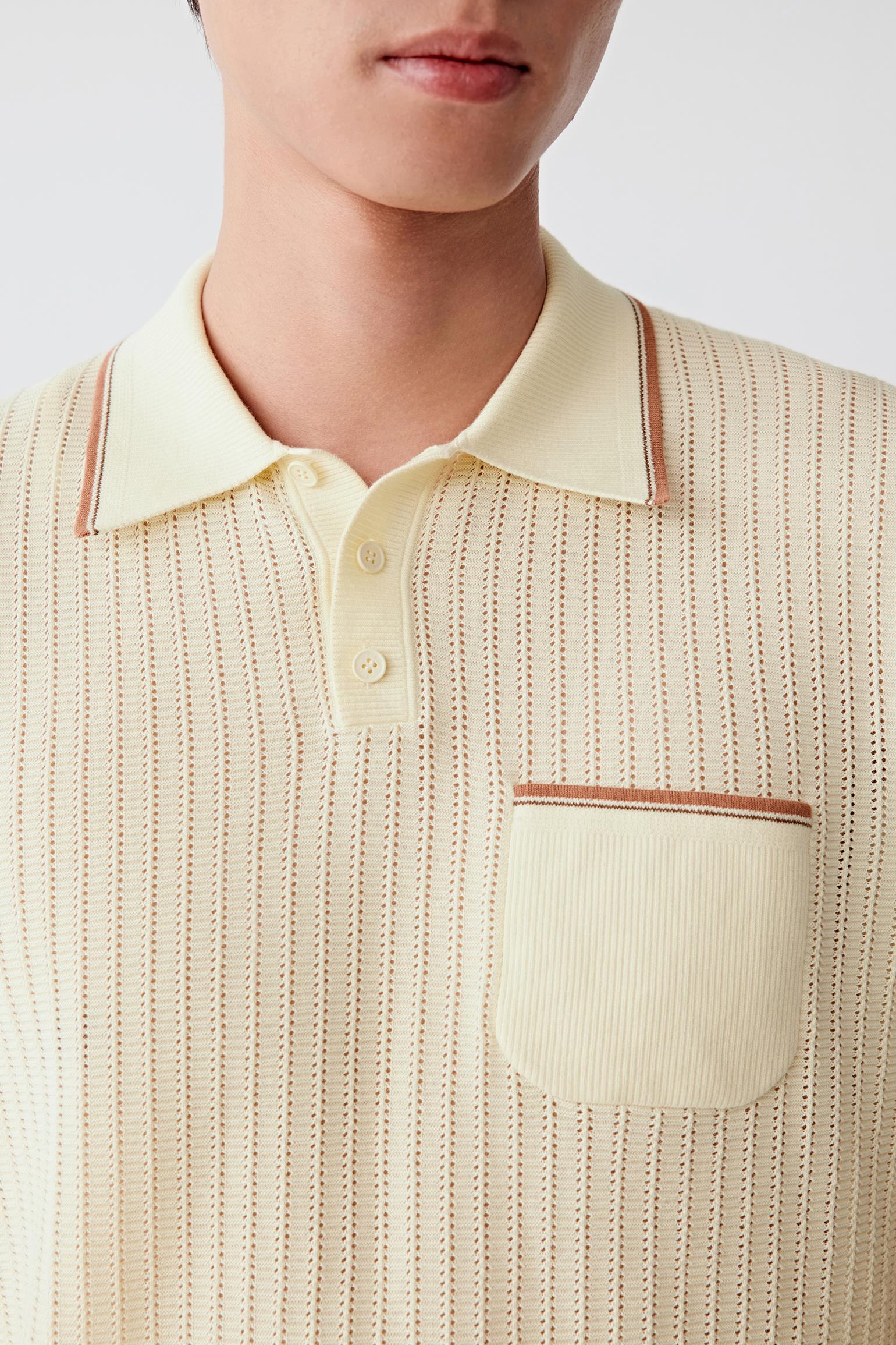 Close-up focusing on the three-button placket and chest pocket with contrasting piping. The image reveals the fine knit structure, precise finishing and subtle detailing that defines the upper construction.