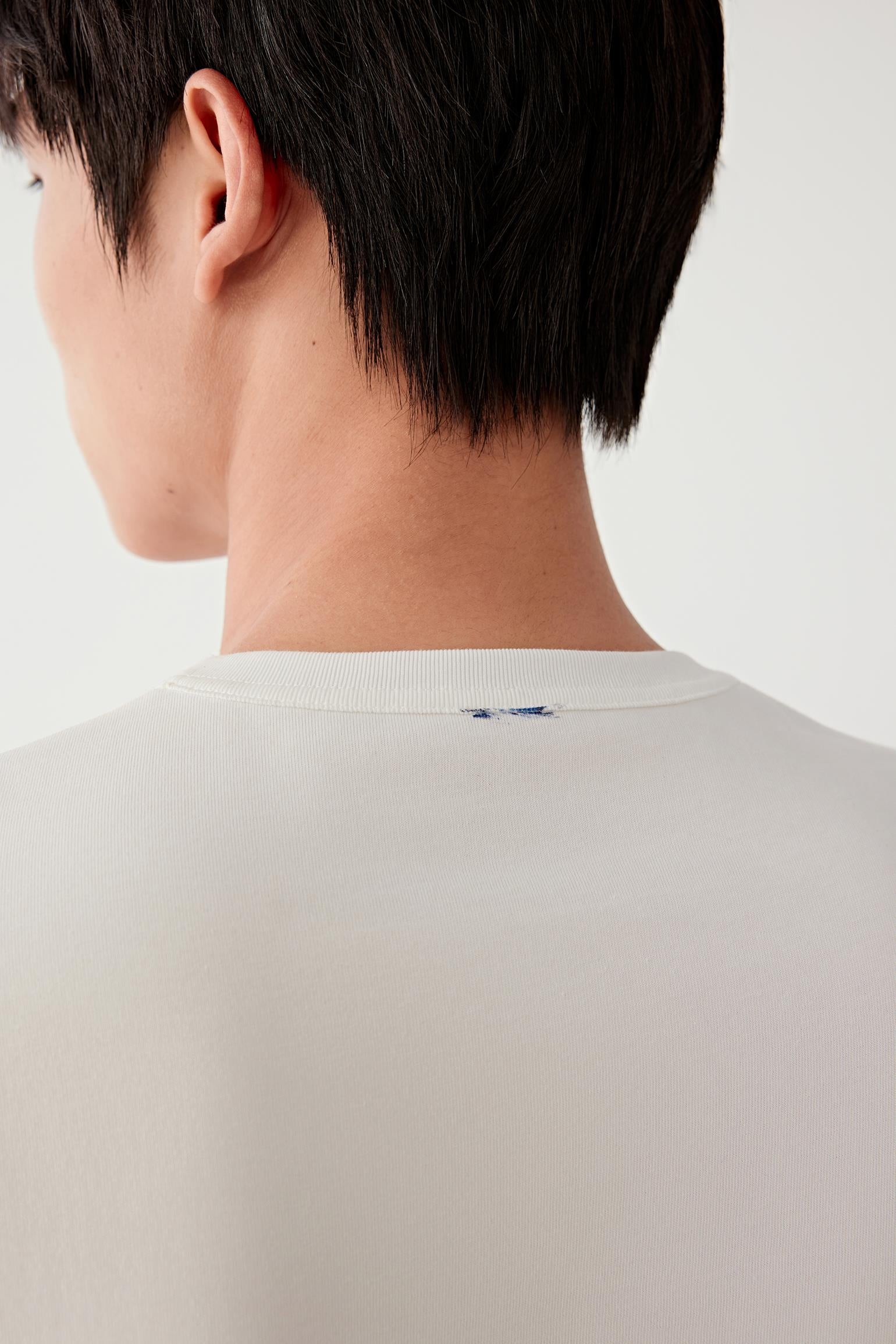 Close-up of the back neckline and upper shoulder, highlighting the clean finishing, seam construction and the smooth jersey surface with a soft hand feel