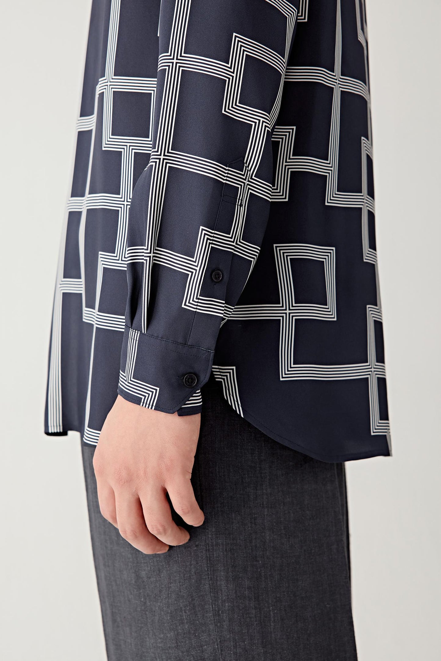 Detail of the sleeve and cuff revealing the crisp finish and graphic lattice design.