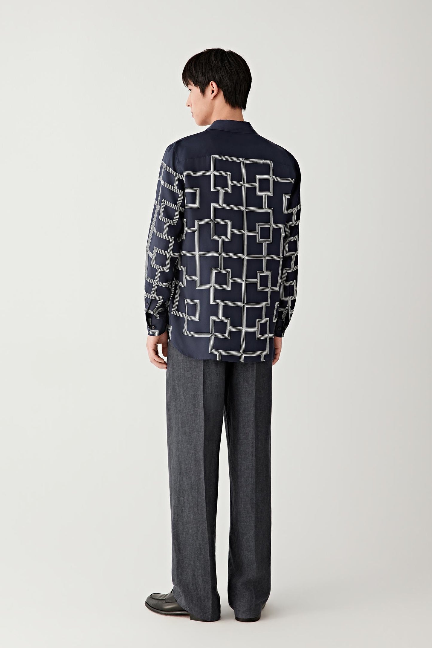 Full-length back view showing the structured straight fit and all-over geometric motif.
