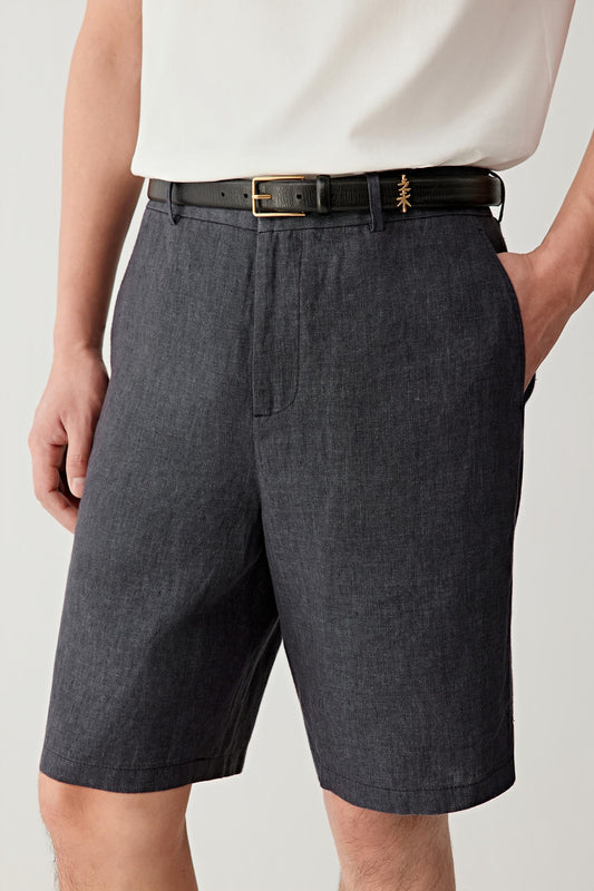 Close-up of the front waist and upper leg, emphasizing the tailored waistband, belt loops and front closure, with visible stitching and a slightly irregular weave that adds depth to the blue-black tone