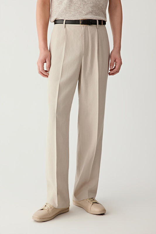Mid-length front view focusing on the waist and upper leg, emphasizing the clean waistband, discreet finishing and the natural fall of the fabric, with the beige tone revealing soft tonal variation and depth in the weave