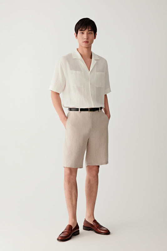 Full-length view showing the shirt paired with coordinating shorts. The image emphasizes the fluid drape, open collar construction and easy proportions of the garment, illustrating its relaxed warm-weather character.