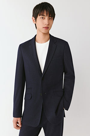Man wearing a dark navy heavy wool jersey blazer with straight fit, styled with matching trousers and white T-shirt, front view.