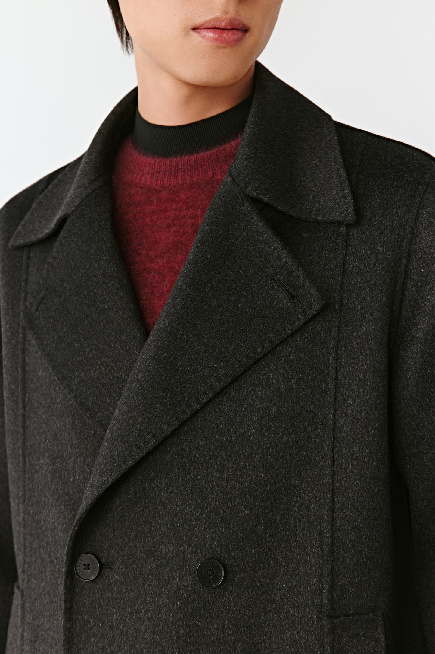 Close-up of dark gray coat with two buttons