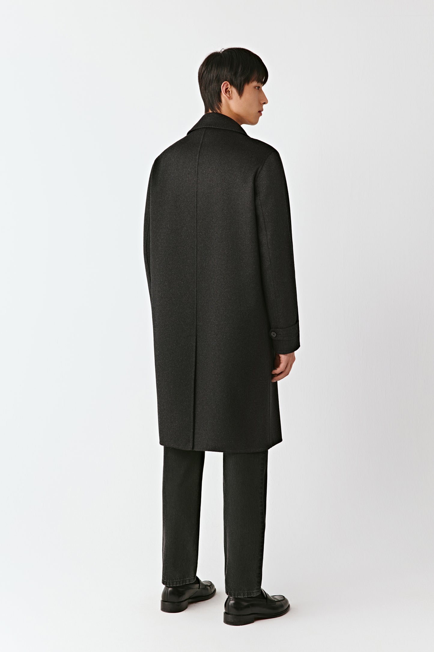 Man wearing a black coat on a white background