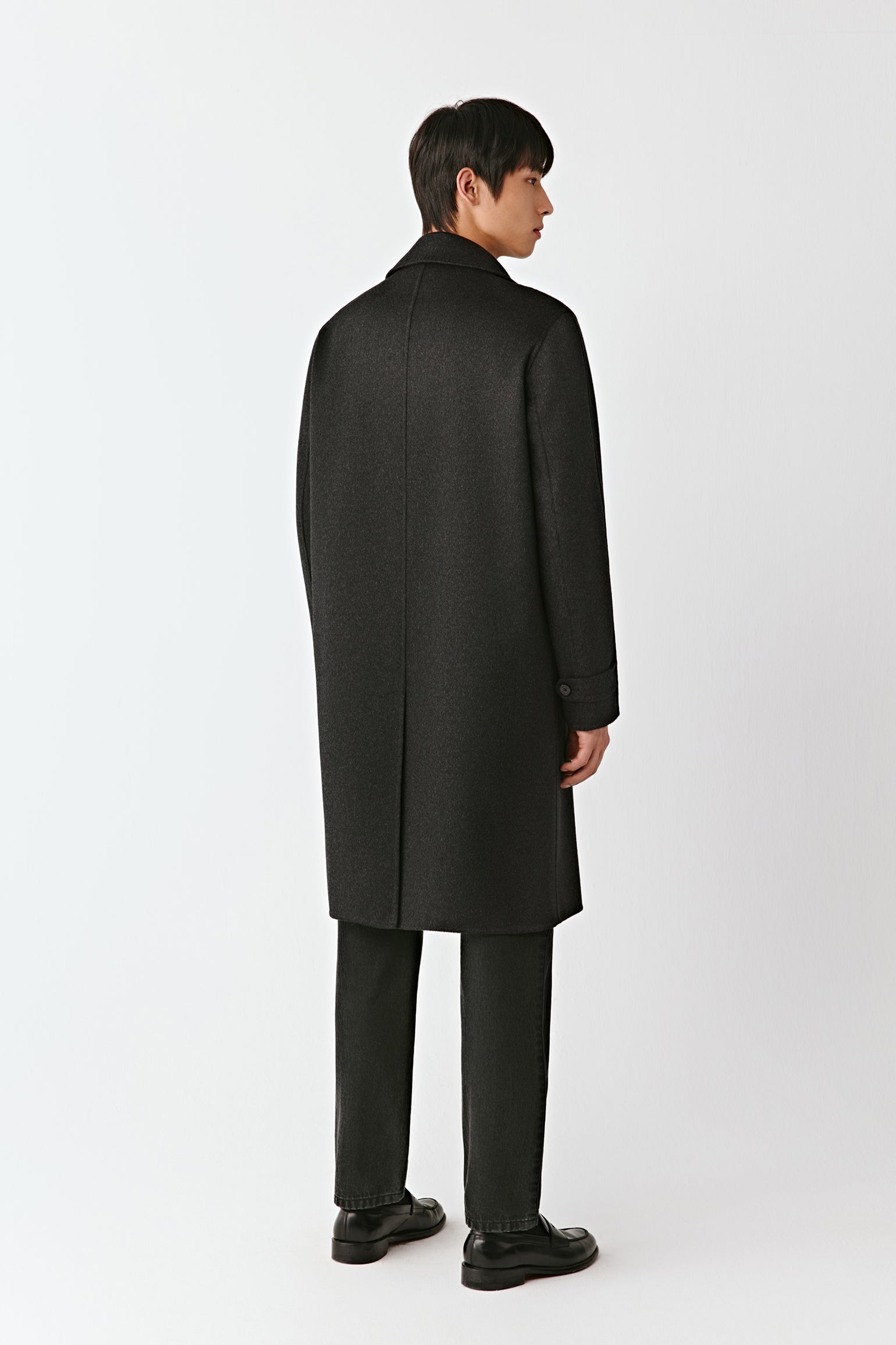 Man wearing a black coat on a white background