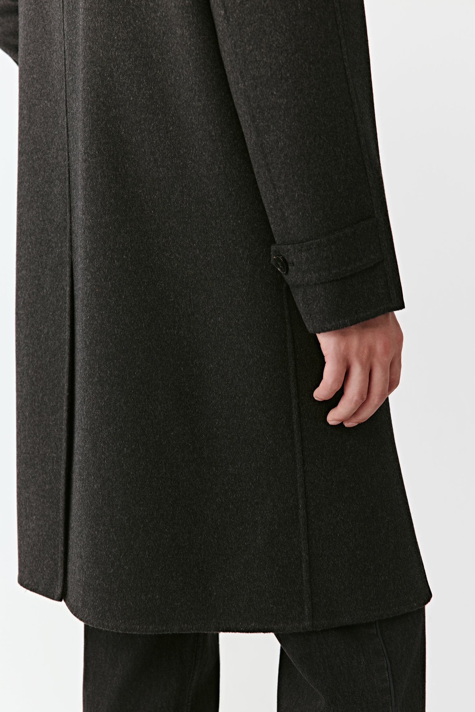 Dark gray coat worn by a person on a white background