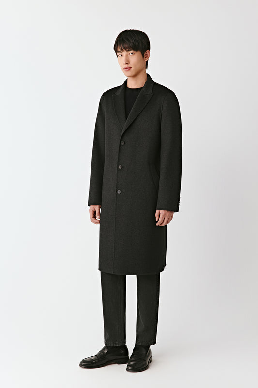 Man wearing a black overcoat on a white background