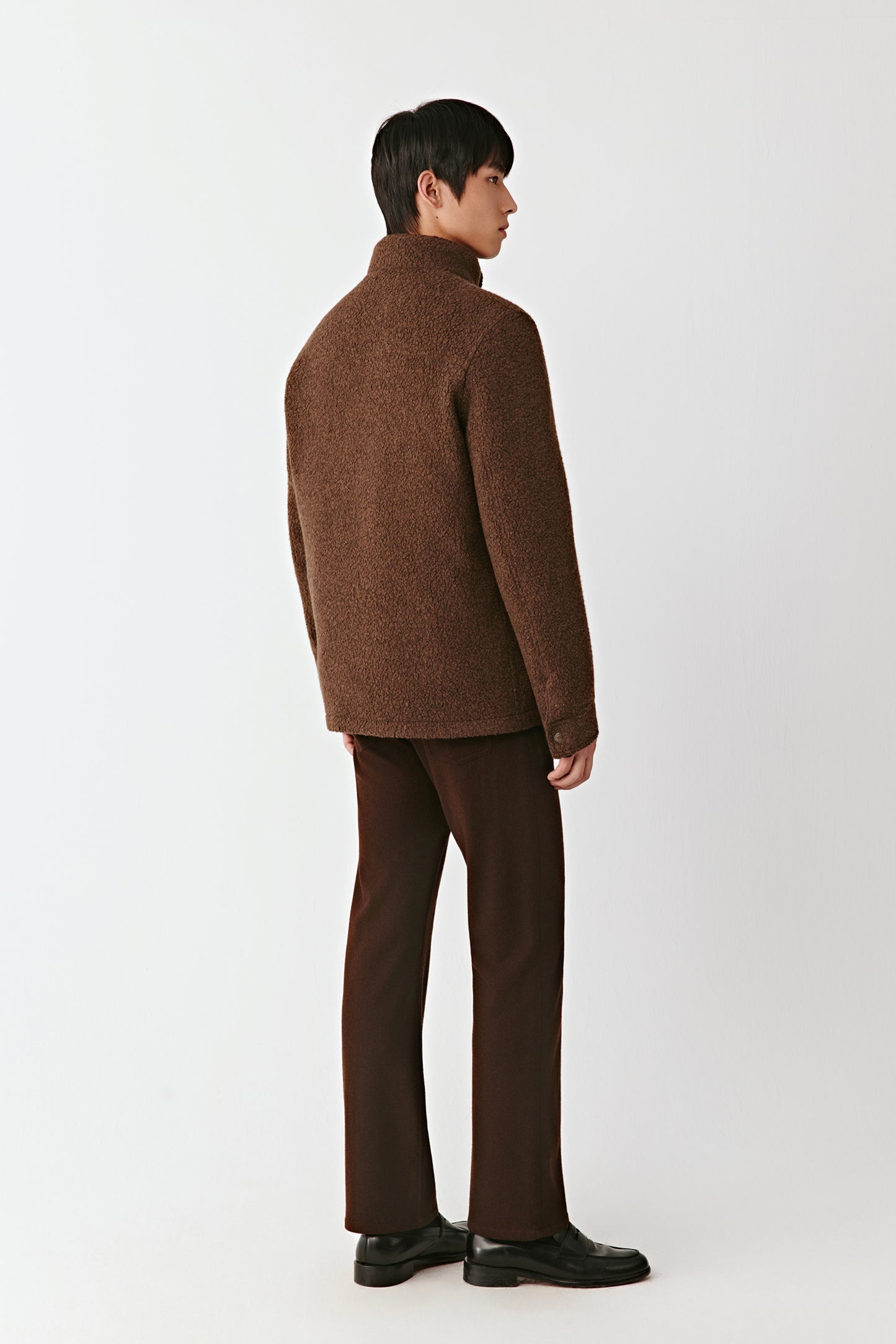 Person wearing a brown suit on a white background