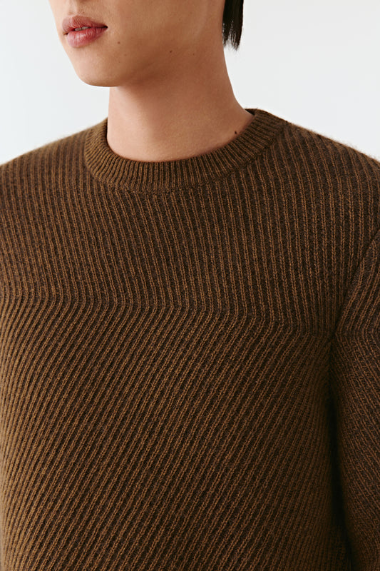 Brown ribbed sweater worn by a person on a white background