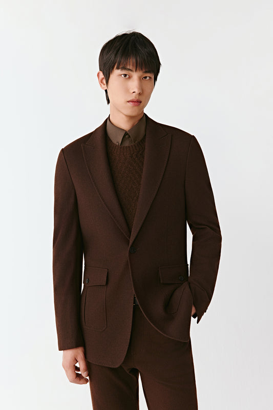 Man wearing a brown suit against a white background