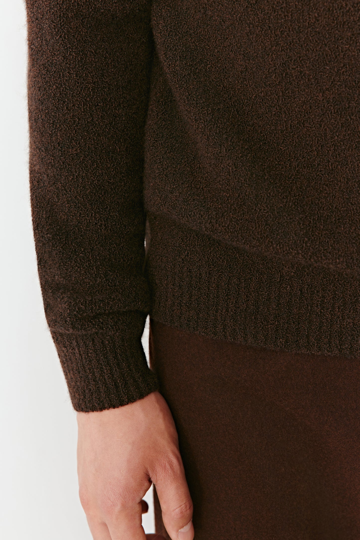 Brown sweater worn by a person on a white background