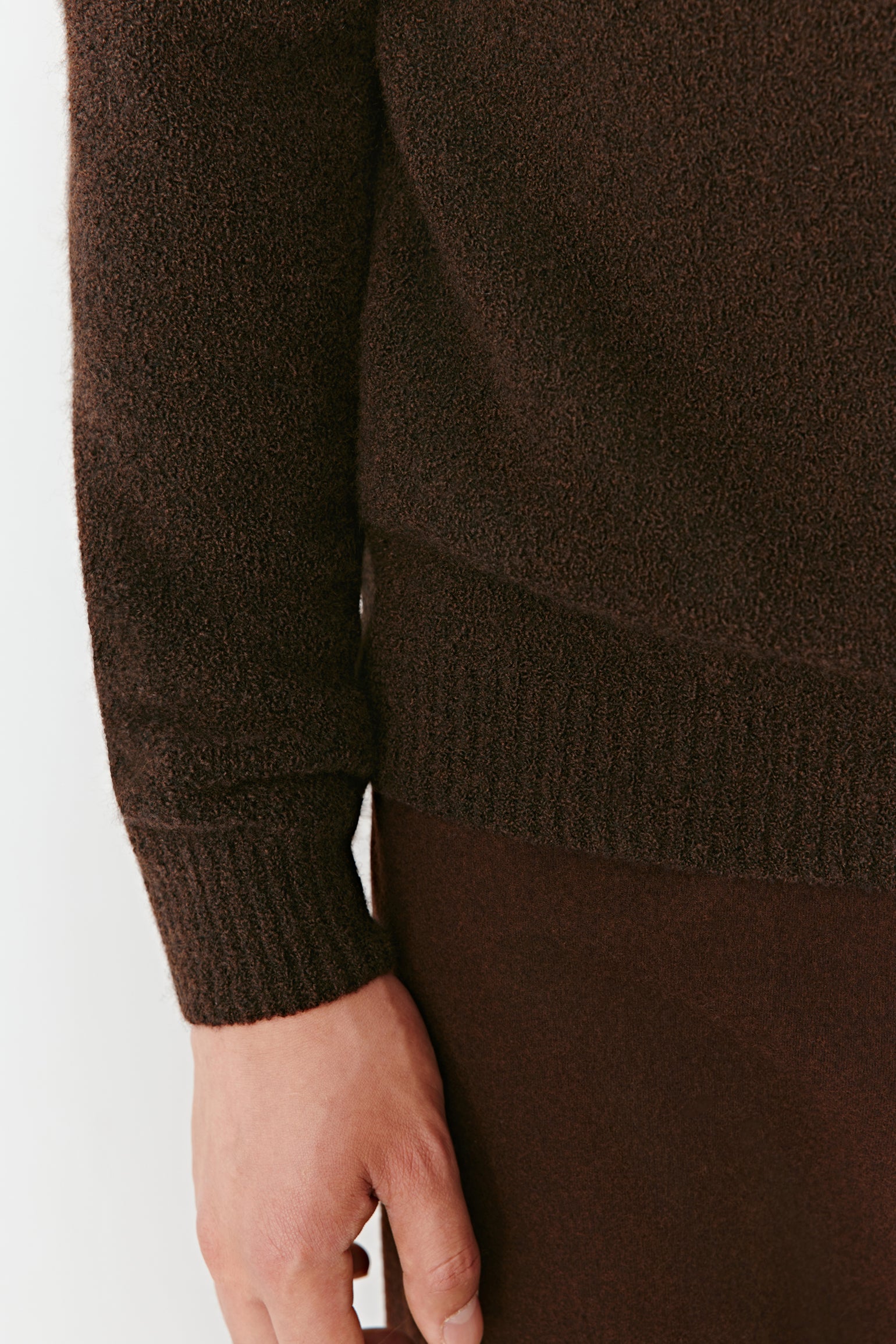 Brown sweater worn by a person on a white background