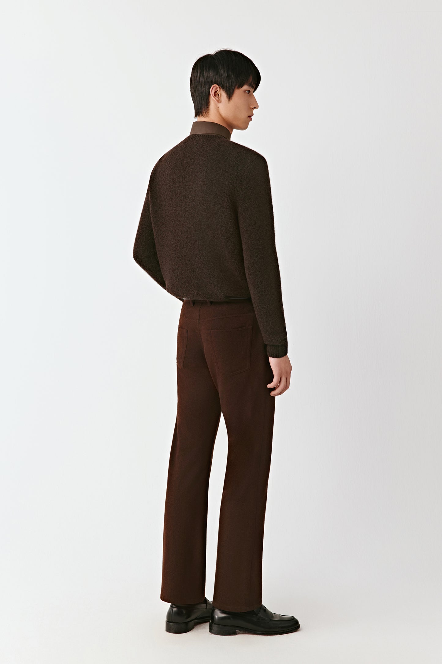 Person wearing a brown outfit on a white background