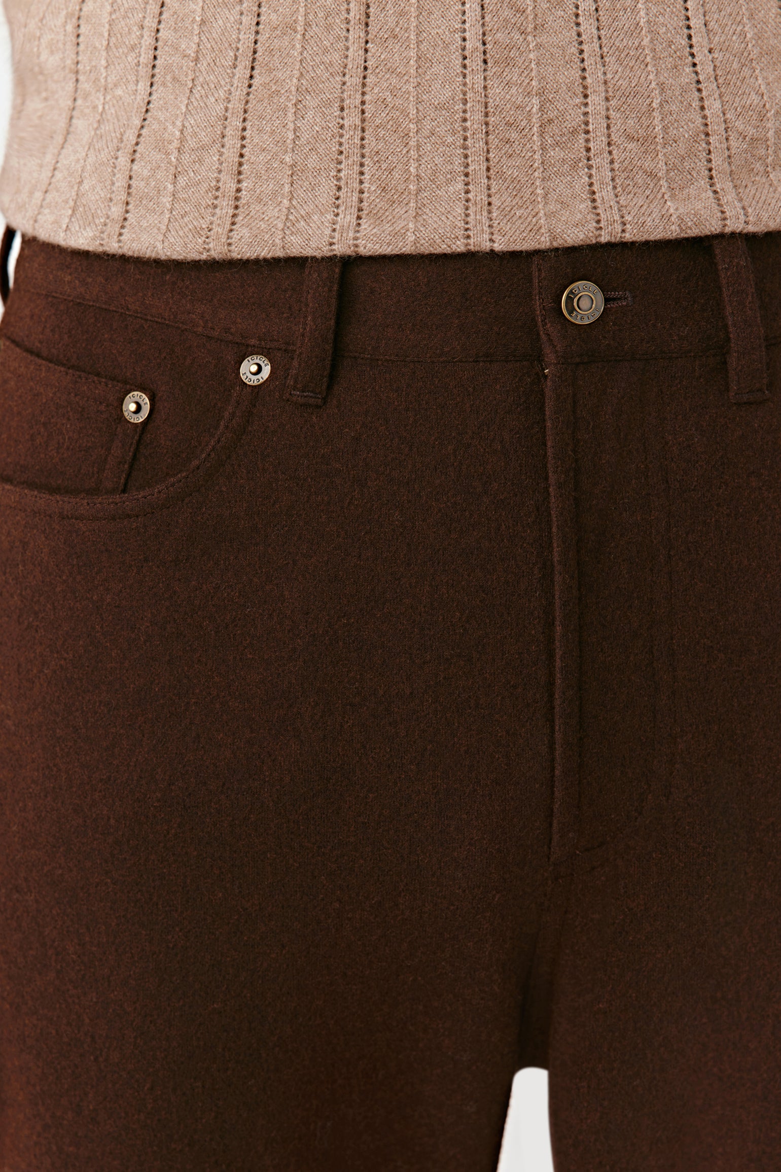 Brown pants with a beige sweater in the background