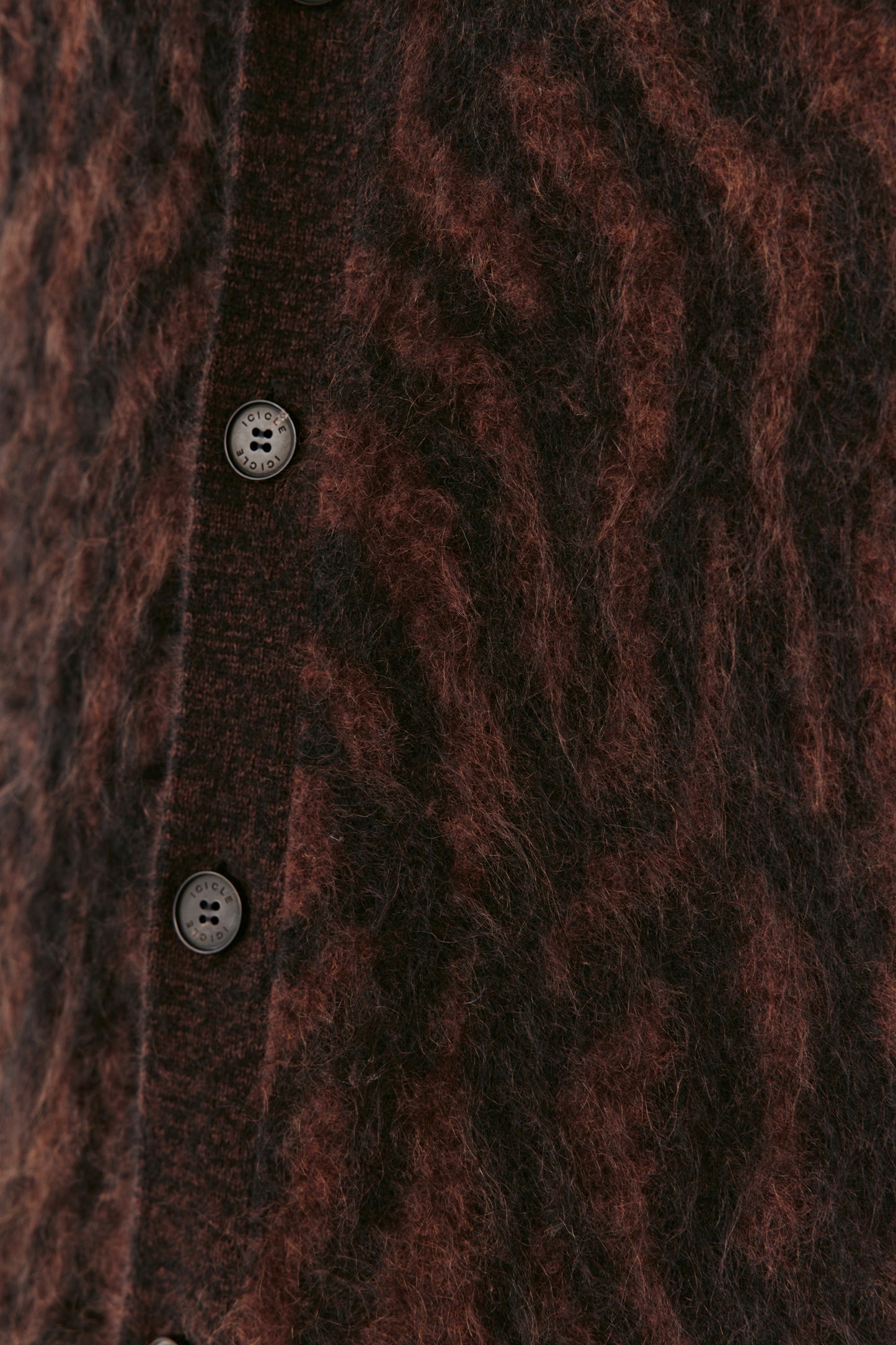 Close-up of a textured brown cardigan with buttons