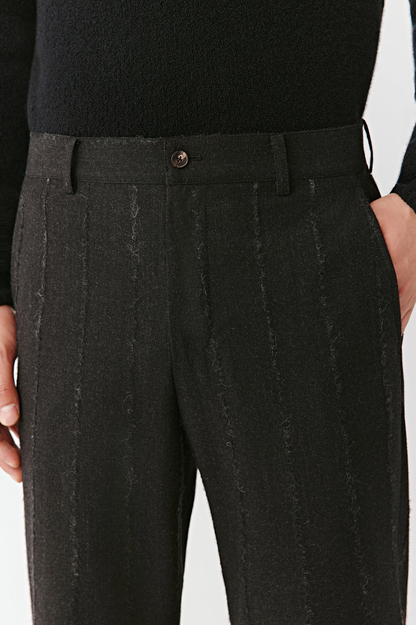 Close-up of the waistband and pinstripe detailing on the wool-blend trousers.