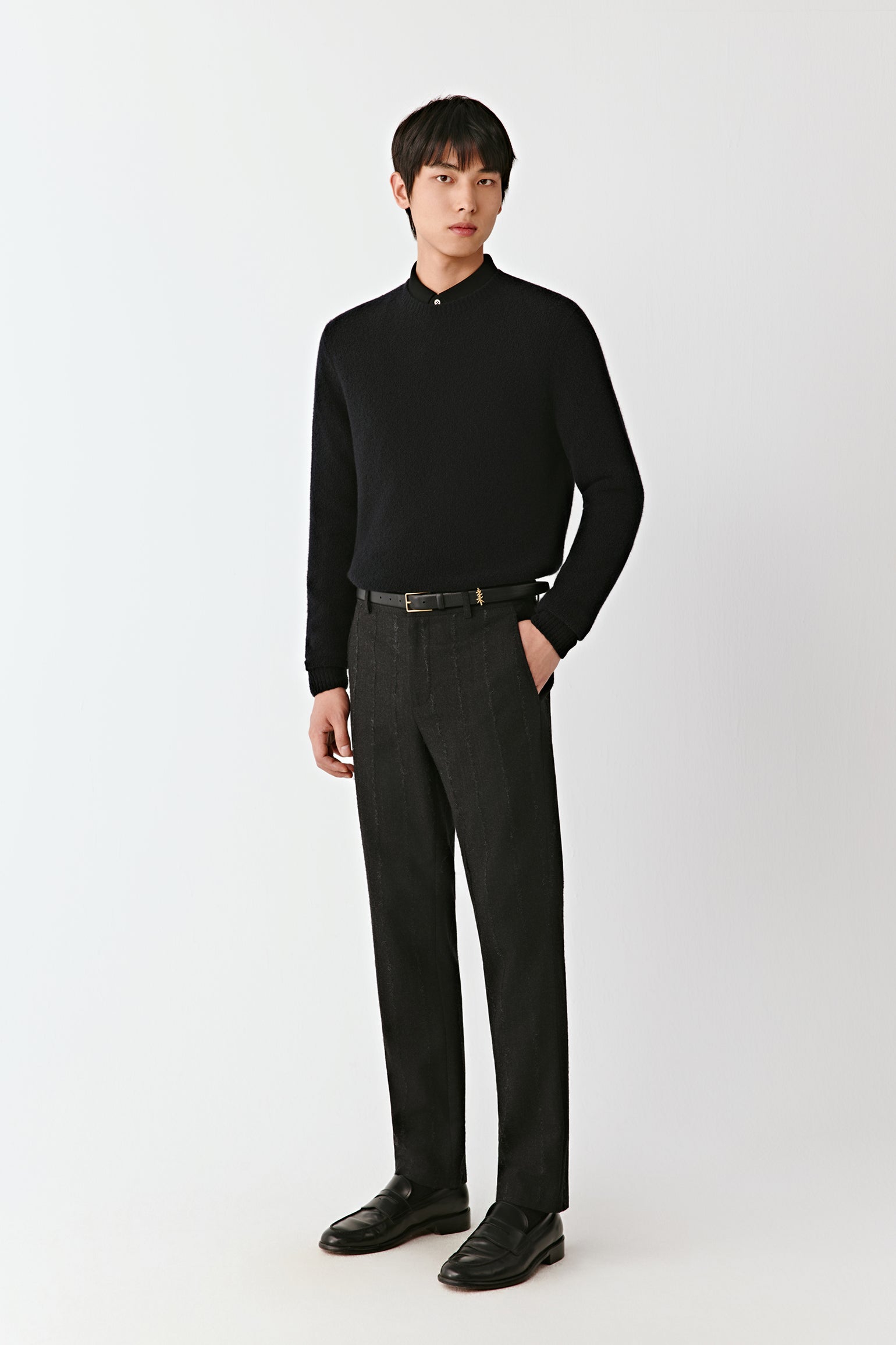Full-length front view of straight-leg trousers in a dark pinstripe wool-blend, styled with a black knit top.