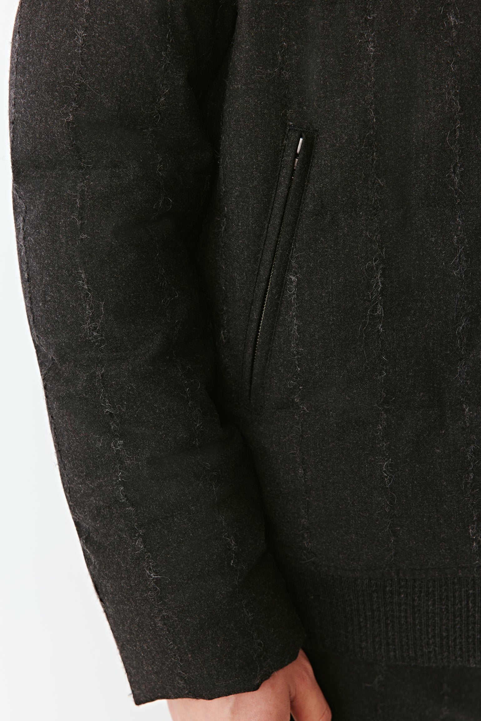 Detail close-up of the sleeve and wool texture of the striped down coat.