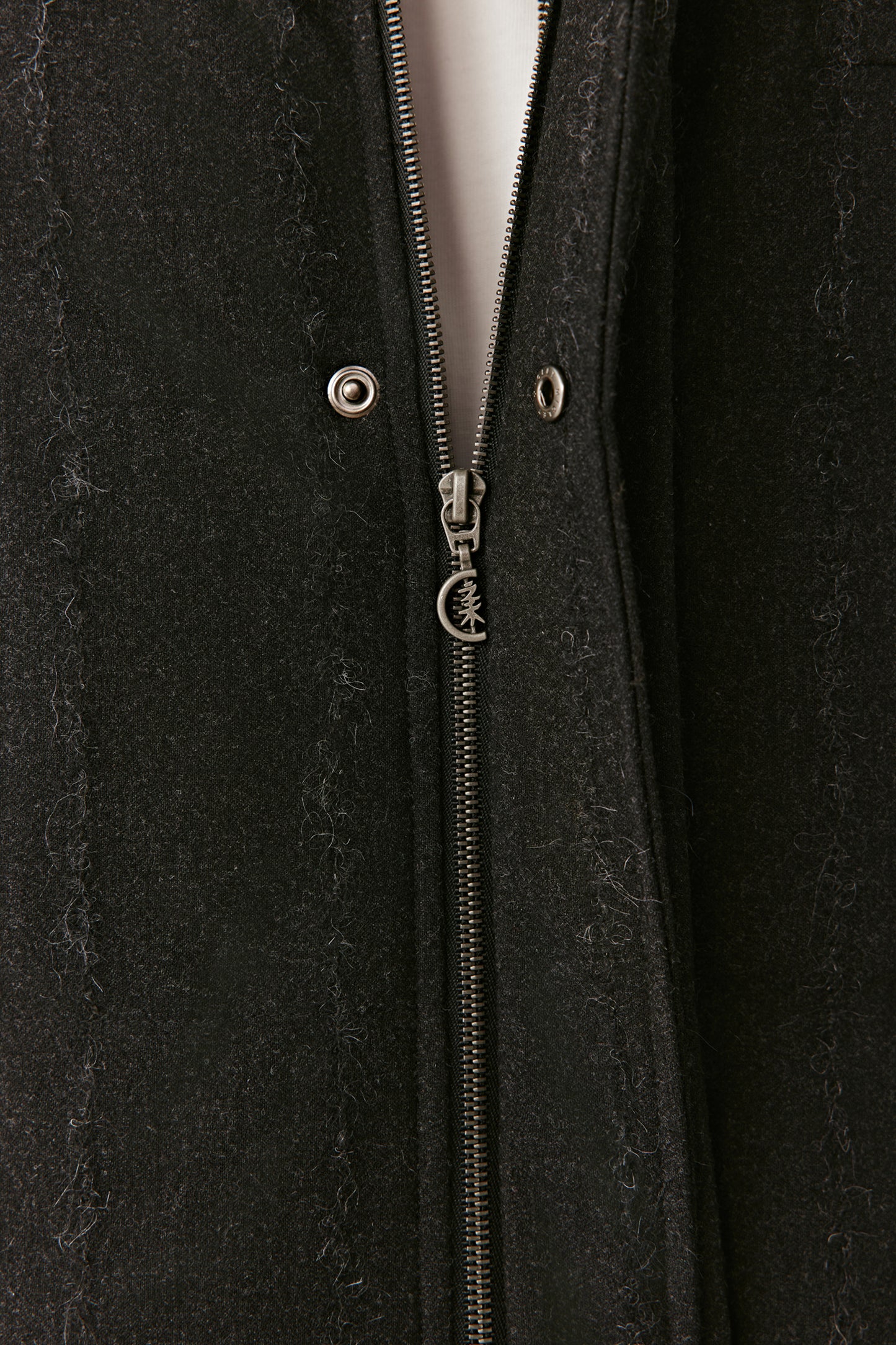 Close-up of the concealed zip fastening on the striped stretch wool down coat.