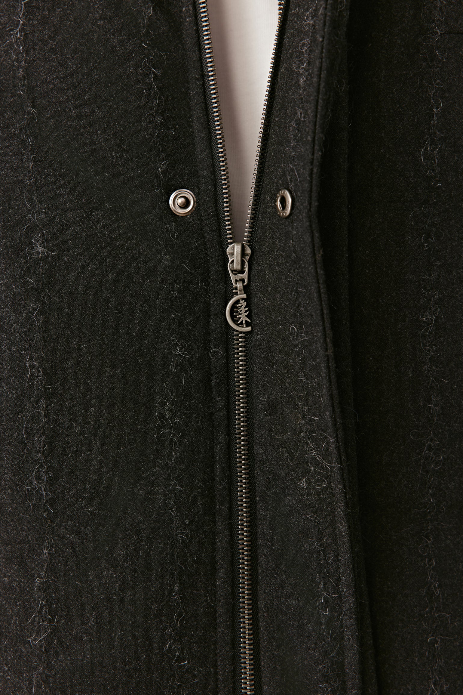 Close-up of the concealed zip fastening on the striped stretch wool down coat.