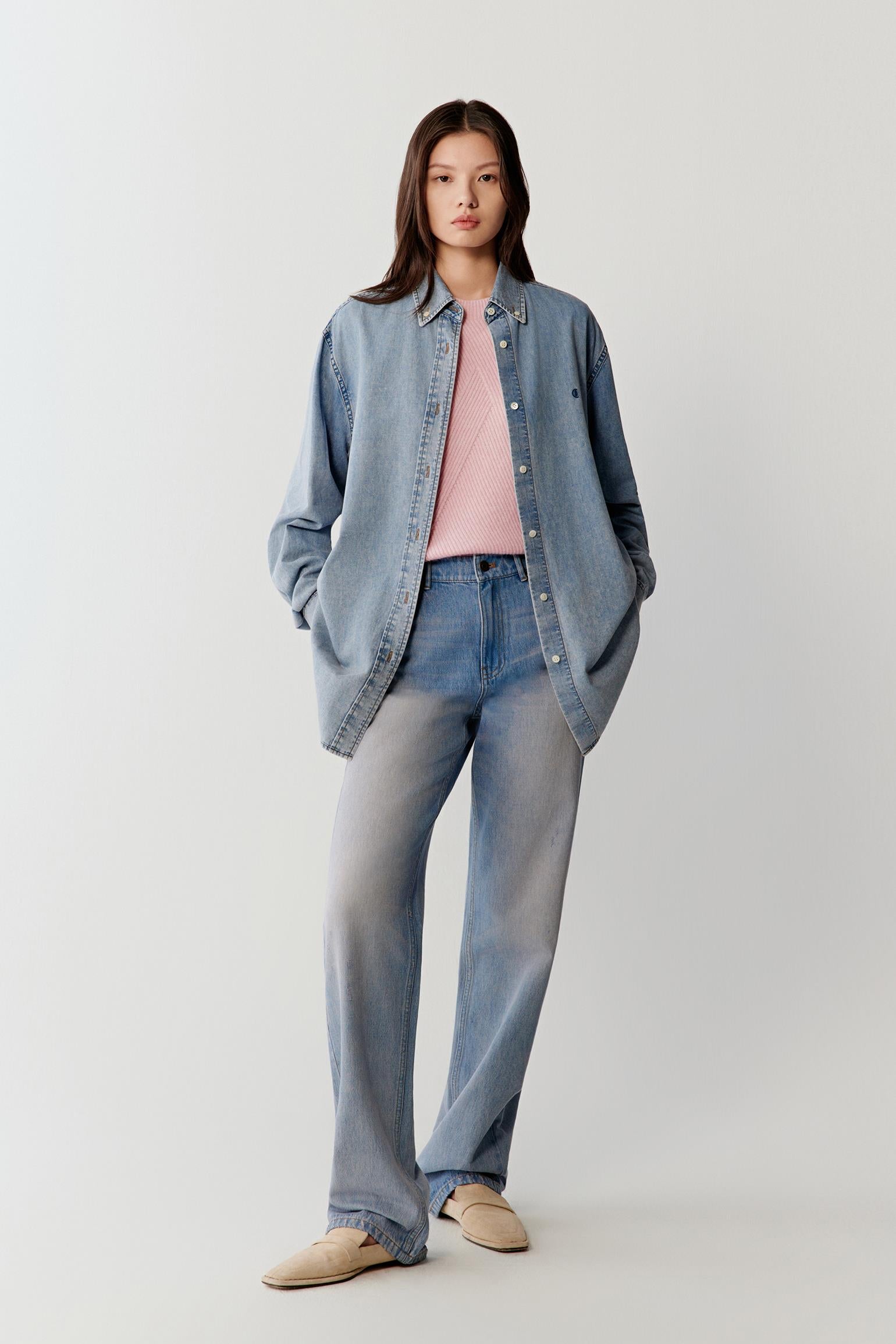 Full-length front view showing the shirt worn closed, highlighting the vertical line, balanced proportions, slightly loose fit and smooth washed denim surface