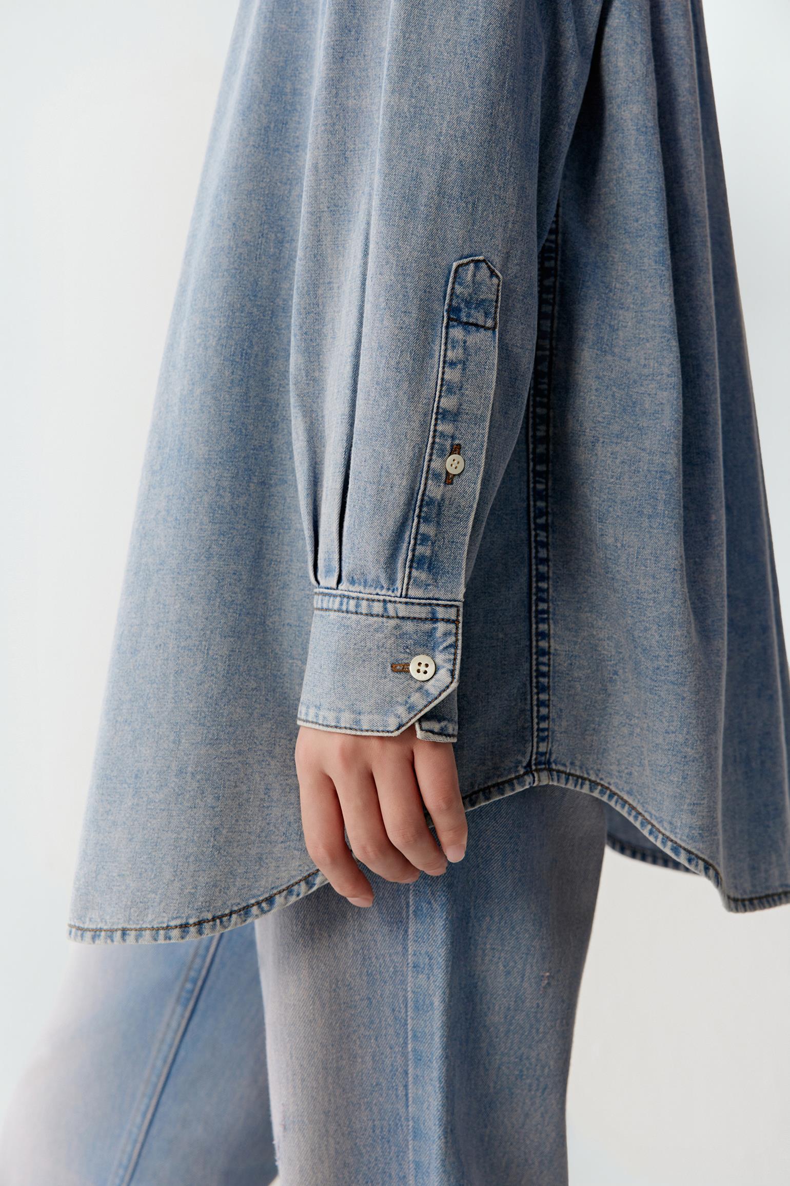 Close-up side view of sleeve and hem showing the fluid structure, soft hand feel and natural movement of the lightweight denim