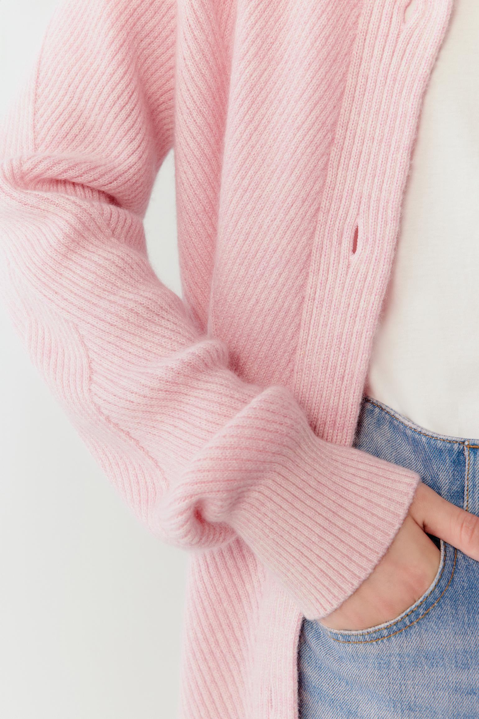 Close-up detail of the sleeve showing the fine knit texture and the clean finishing of the cuff.