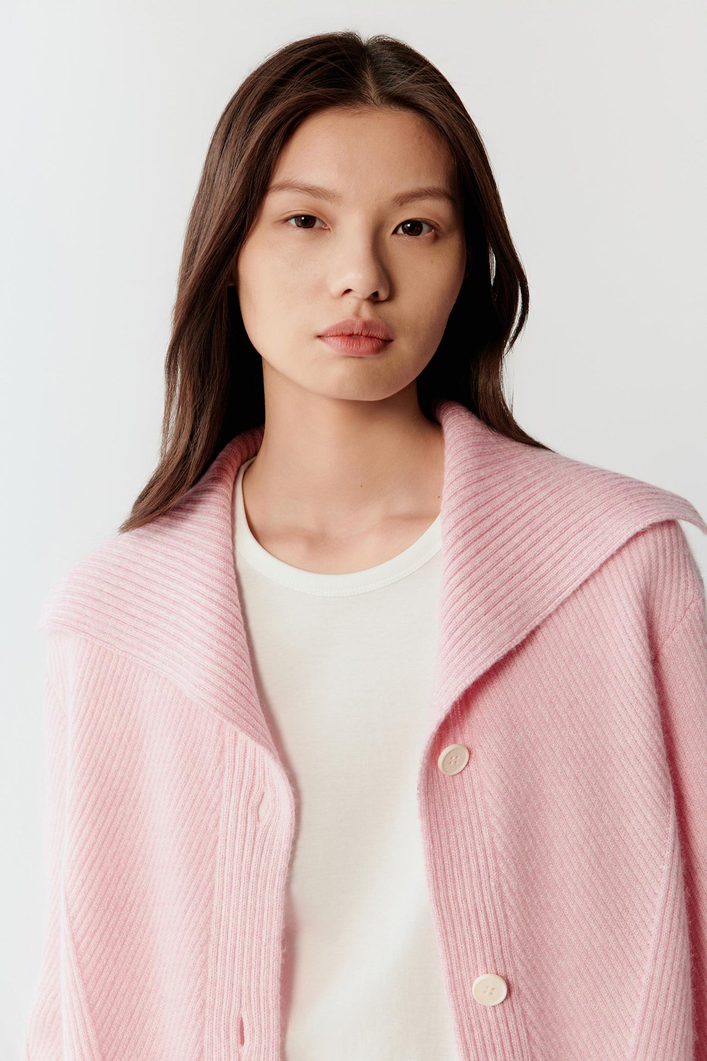 Close-up portrait focusing on the round neckline and upper chest area, highlighting the soft knit structure.