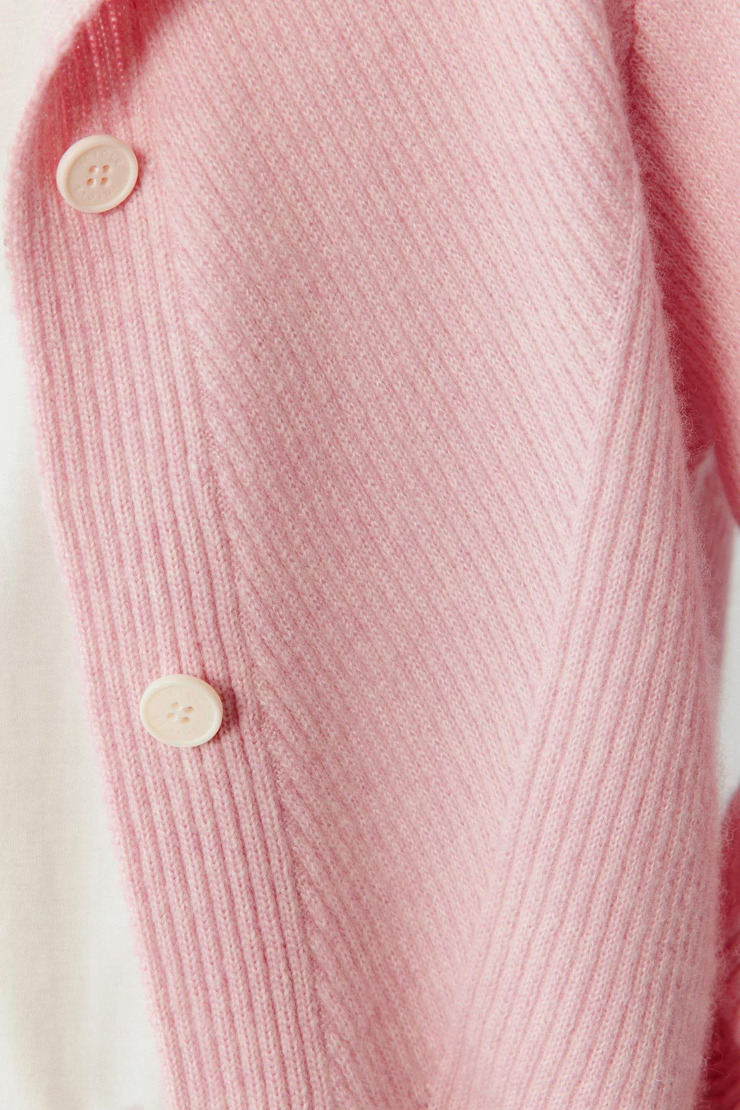 Close-up detail of the front placket highlighting the tonal buttons and the textured knit surface.