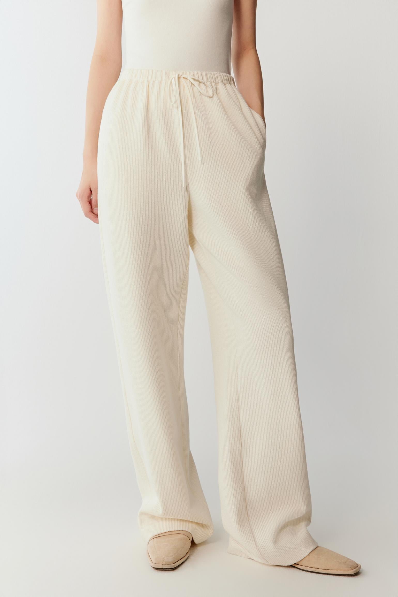 Three-quarter view highlighting the fluid drape of the ribbed jersey fabric and the relaxed proportions of the silhouette.