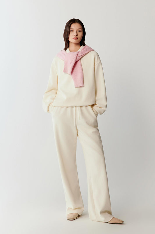 Female model wearing cream ribbed jersey trousers with elasticated drawstring waistband.